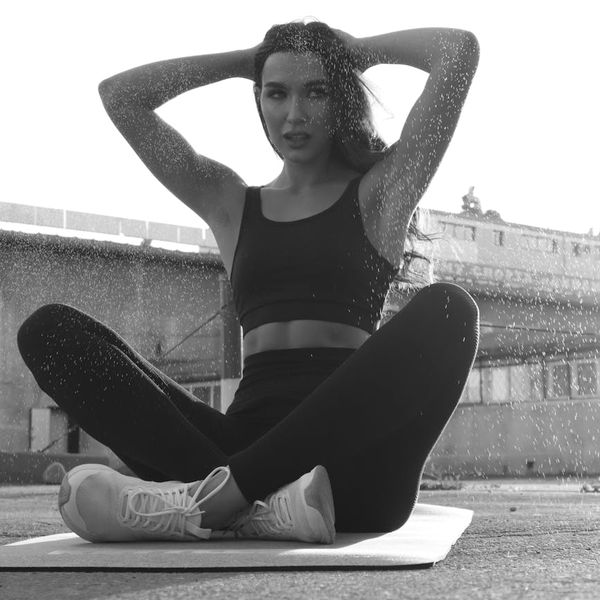 Person in a balancing yoga pose in a monochrome setting with lime accents.